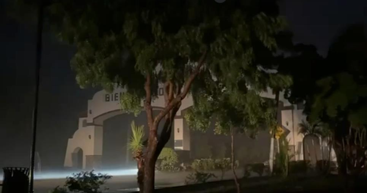 Arco de bienvenida en Badiraguato rodeado de árboles y neblina nocturna