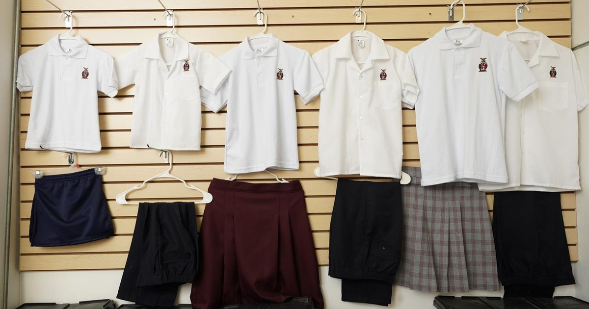 Uniformes escolares colgados en un panel, listos para distribución gratuita en Sinaloa.