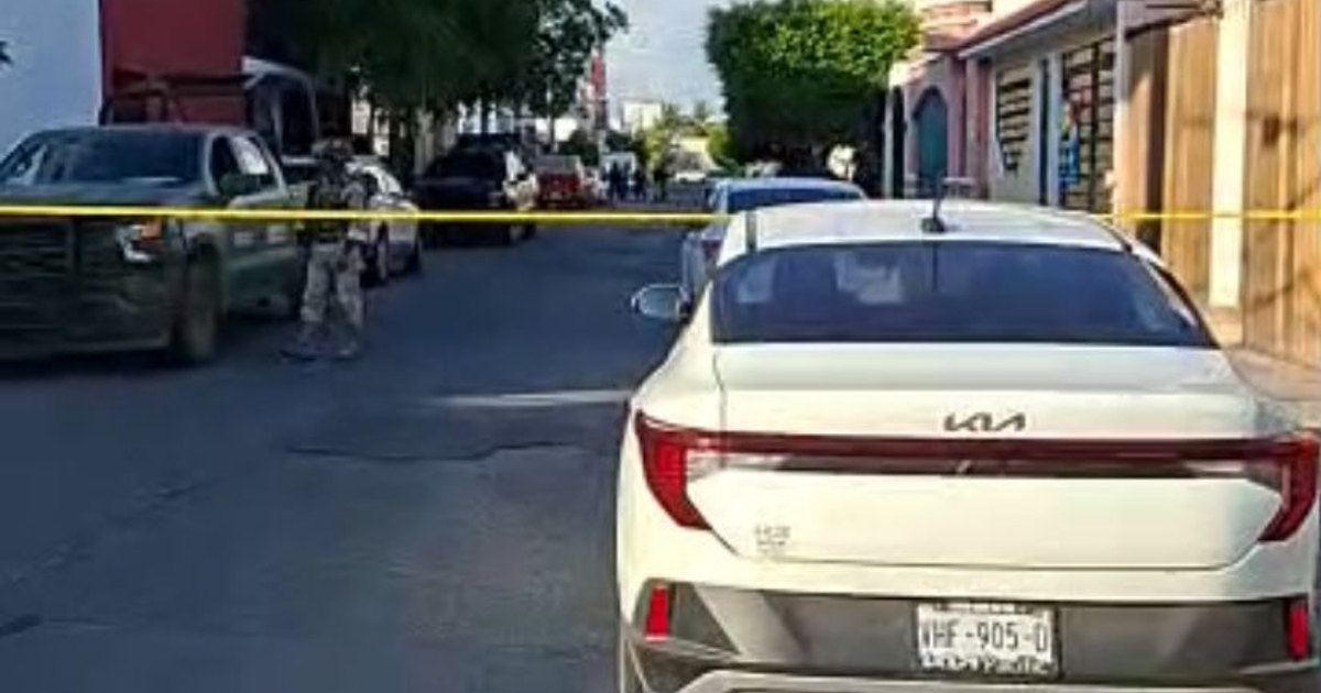 Calle en Mazatlán con vehículos, agente de seguridad y cinta amarilla de restricción.