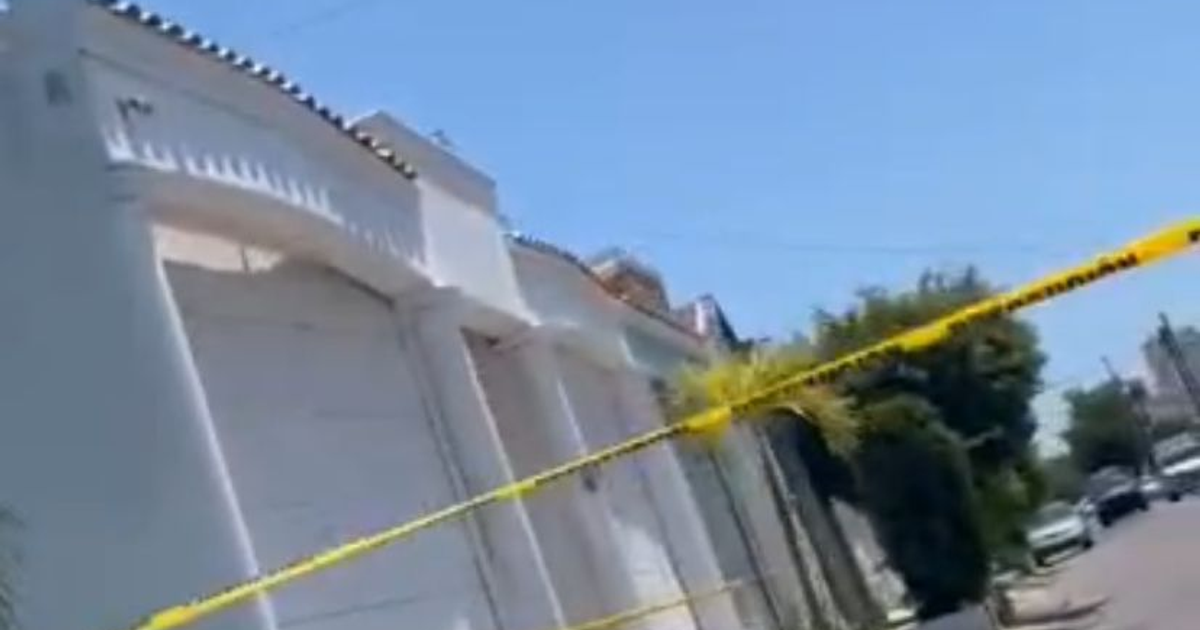 Calle en Mazatlán con cinta de seguridad y edificio blanco al fondo, relacionada con el hallazgo de un vehículo en investigación.