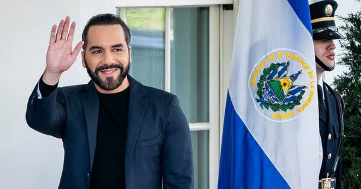 Persona sonriente saludando junto a una bandera centroamericana y un guardia de honor en El Salvador.