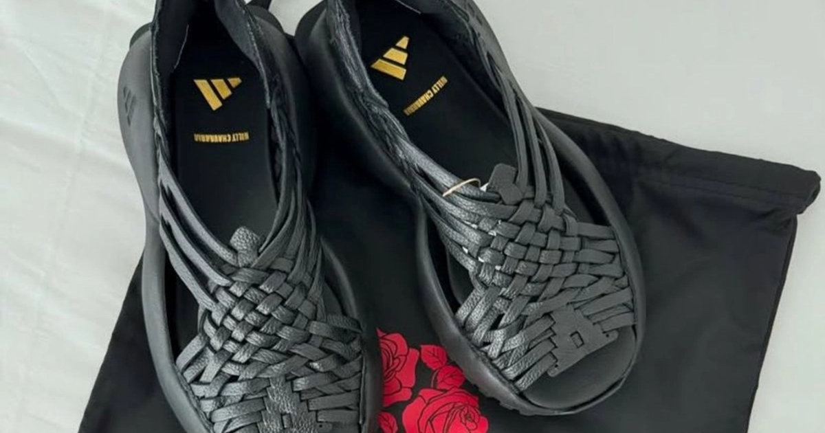 Zapatos negros trenzados sobre superficie blanca con bolsa de rosas rojas