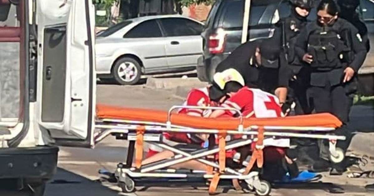 Paramédicos de la Cruz Roja atienden a una víctima en Culiacán tras un ataque, con una ambulancia y vehículos de emergencia en la escena.
