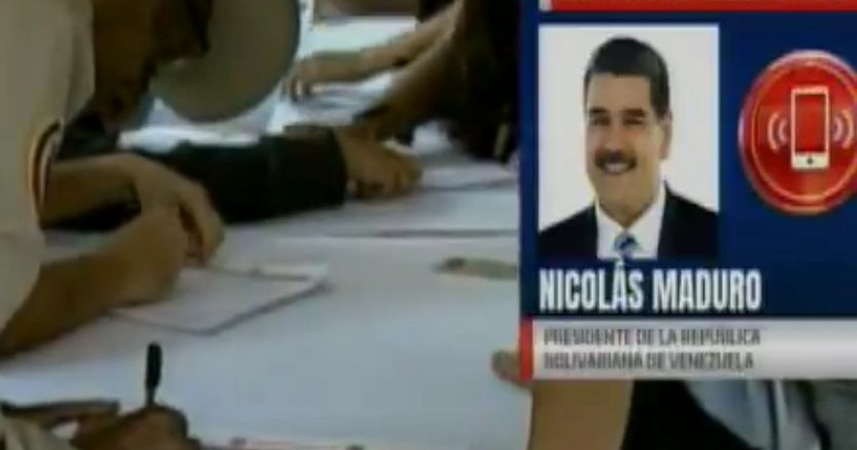 Personas en reunión formal en Venezuela con imagen de Nicolás Maduro en contexto de alistamiento militar.