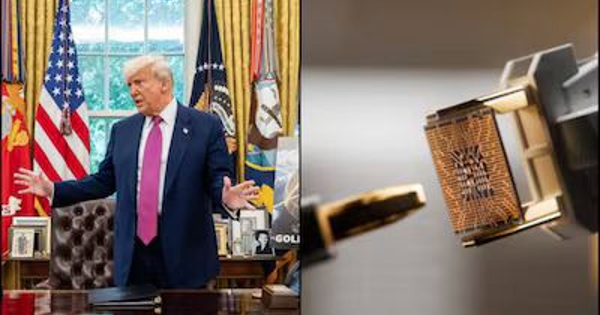 Funcionario en oficina con banderas y componente electrónico en fondo neutro, relacionado con medidas arancelarias para semiconductores.