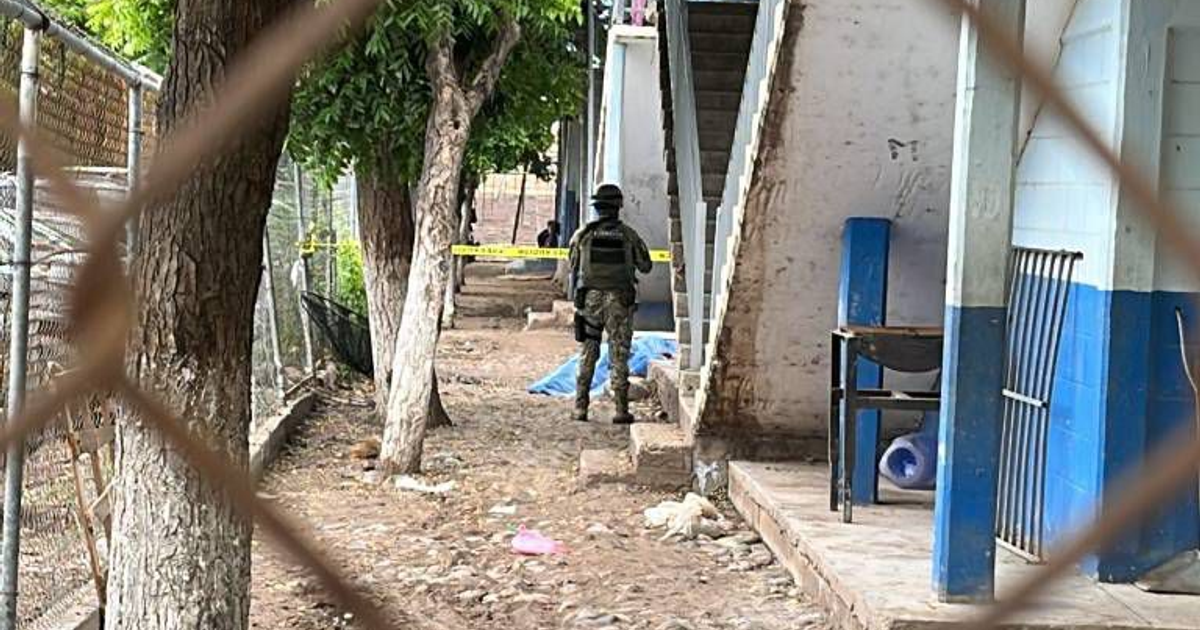Soldado o policía en escena del crimen en Culiacán, cerca de una escalera con cinta de precaución.