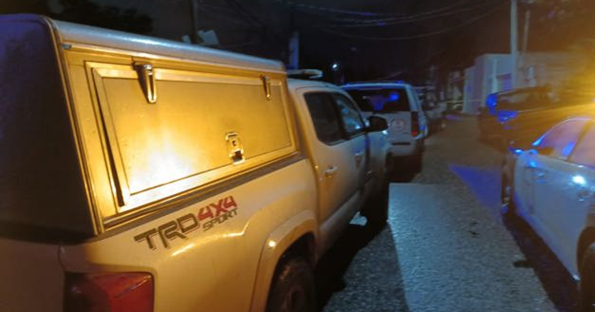 Calle nocturna en Culiacán con vehículos estacionados e iluminación de emergencia, relacionada con un ataque armado.