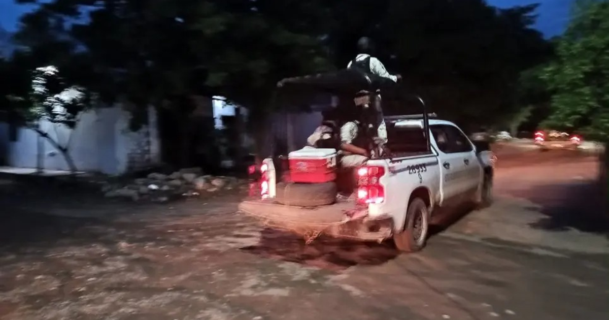 Camioneta blanca en calle nocturna de Culiacán con personas y contenedor en la parte trasera