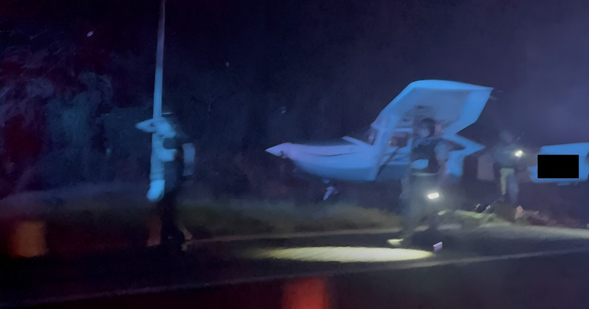 Inspección nocturna de avioneta en autopista por personal de seguridad