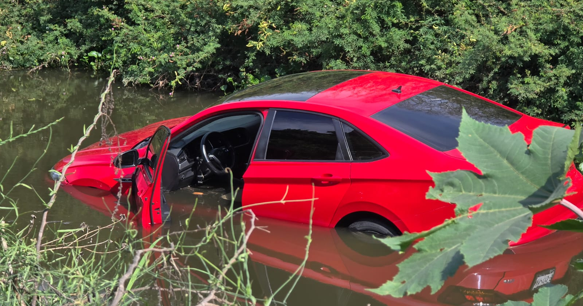 Volkswagen Jetta rojo sumergido en canal 7 de Culiacán con puerta abierta