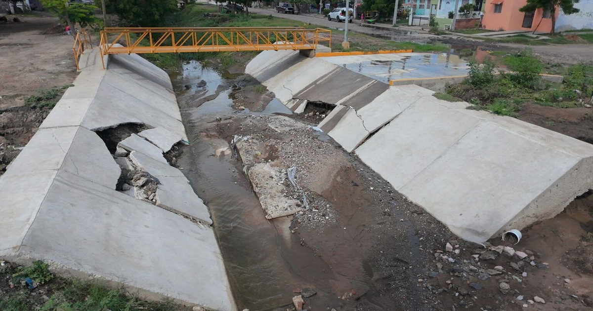 Canal de concreto dañado con puente naranja colapsado en Mazatlán