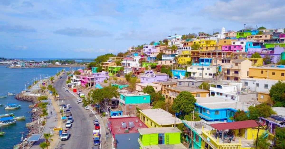 Vista colorida de casas costeras en comunidad afectada por corte de agua