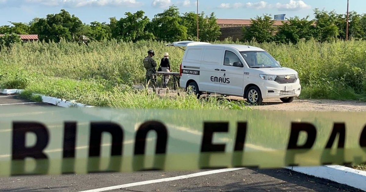 Área con hierba alta, vehículo de Emaús, personas y cinta amarilla en escena de posible incidente en Culiacán.