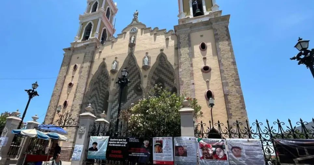Fachada de la Catedral de Mazatlán con pancartas de desaparecidos y veladoras encendidas.