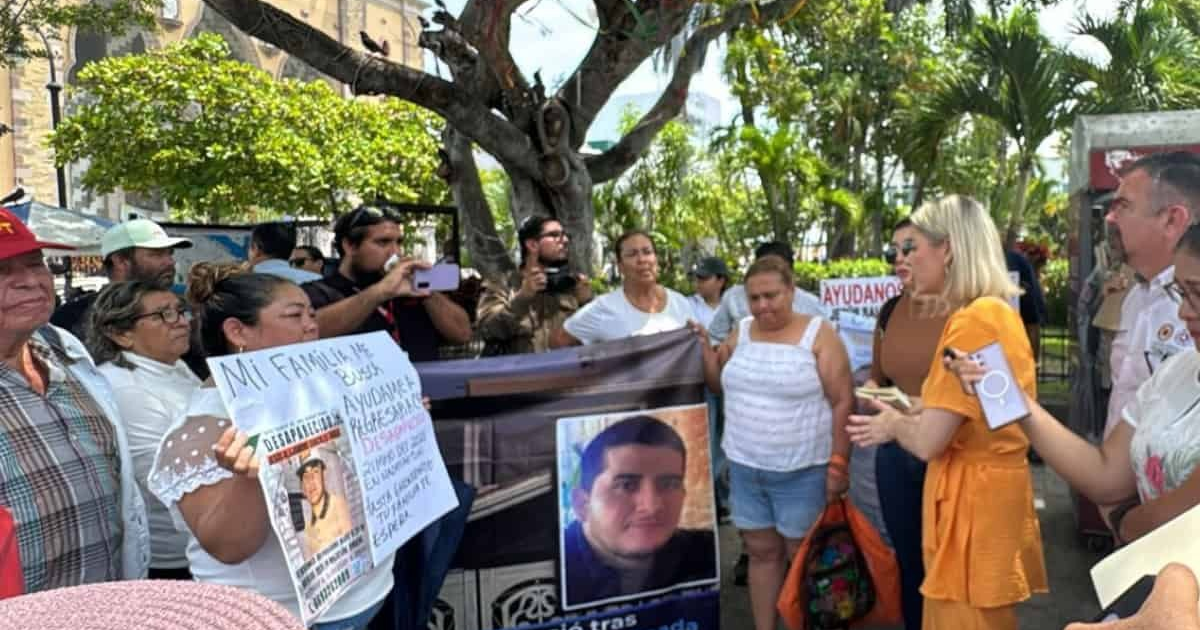 Manifestación en Culiacán por desaparecidos, con personas sosteniendo pancartas en un parque.