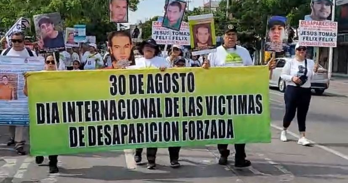 Protesta en Culiacán por el Día Internacional de las Víctimas de Desaparición Forzada, con personas sosteniendo pancartas y fotos de desaparecidos.