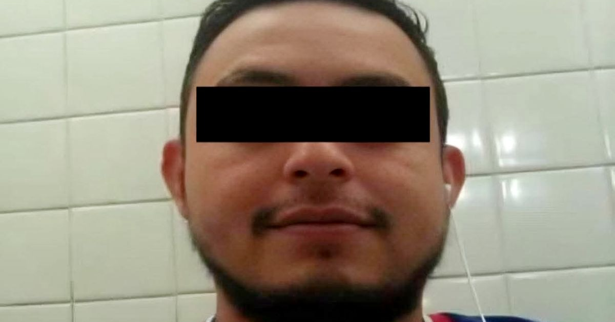 Hombre con barba y auriculares en selfie, fondo de azulejos