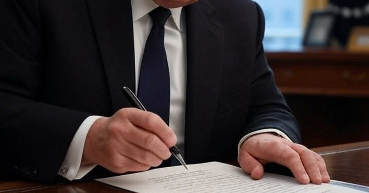 Hombre firmando documento en oficina, relacionado con directiva del Pentágono sobre cárteles.