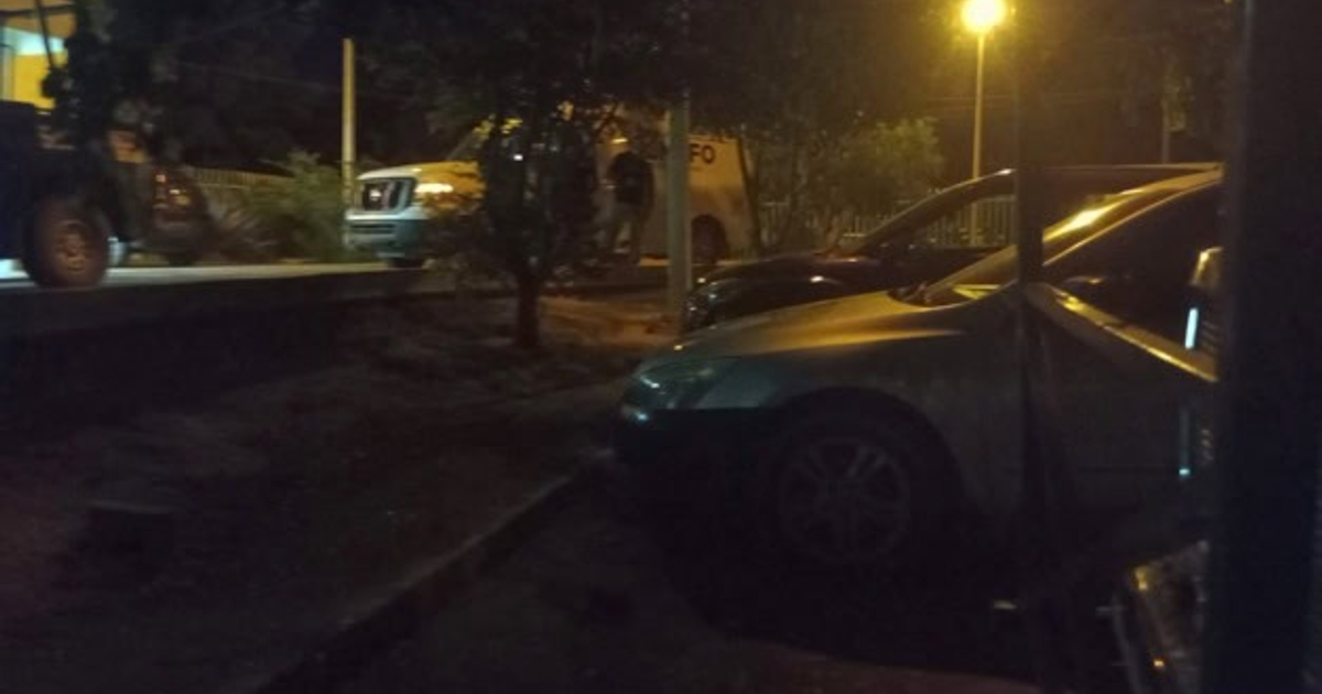 Vehículos estacionados en Navolato bajo la luz de un farol en un entorno nocturno.