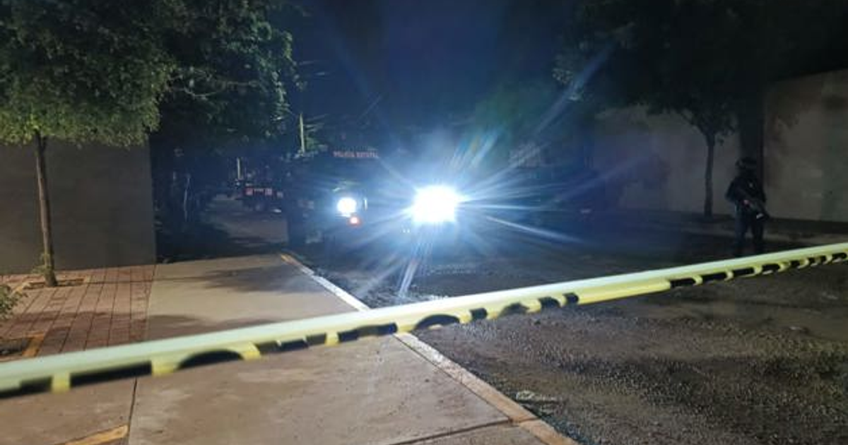 Vehículo policial con luces encendidas y cinta amarilla en operativo nocturno en Culiacán