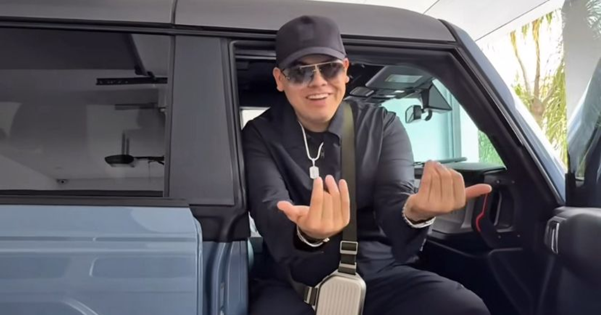 Persona con gafas de sol sonriendo dentro de un coche moderno