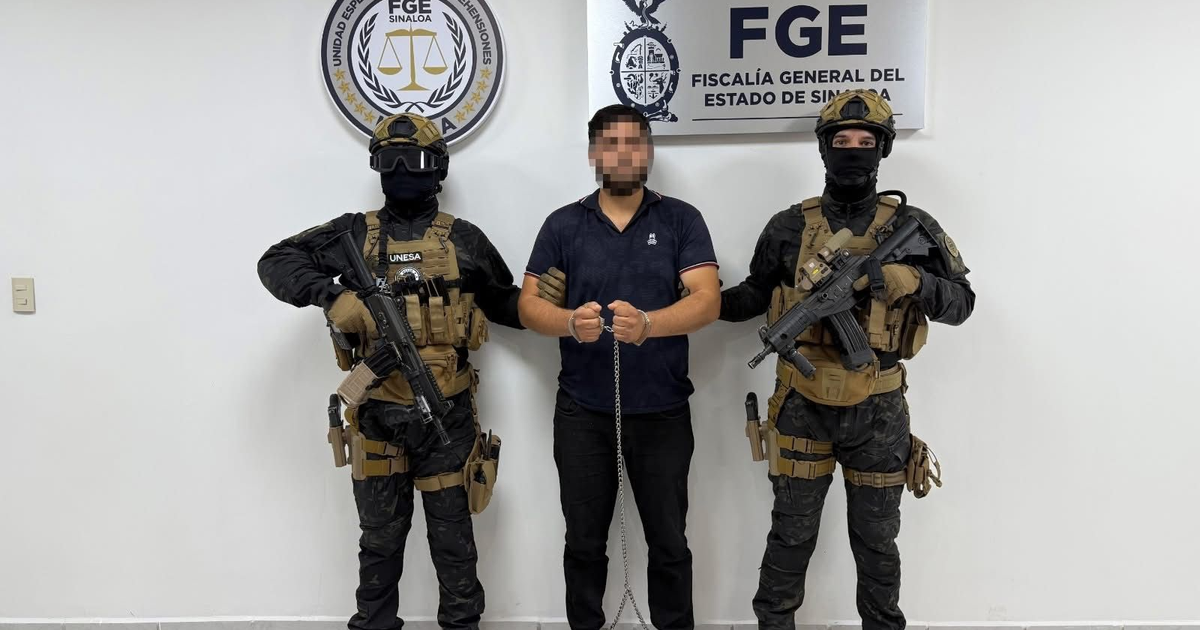 Hombre esposado bajo custodia de agentes de seguridad en Sinaloa