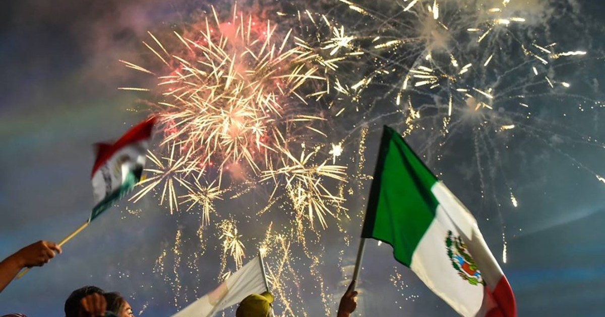 Fuegos artificiales y banderas mexicanas durante celebración en Sinaloa