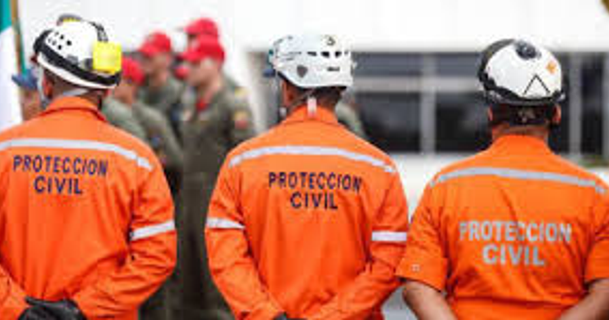 Miembros de Protección Civil con uniformes naranjas y cascos en un evento de seguridad.