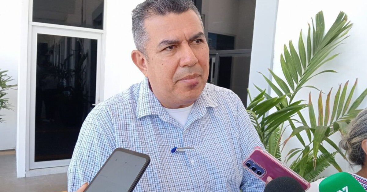 Hombre hablando con dispositivo móvil en ambiente formal, relacionado con deuda del Gran Acuario Mazatlán.