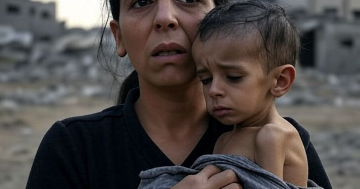 Mujer sosteniendo a un niño en un área devastada, reflejando la crisis humanitaria en Gaza.