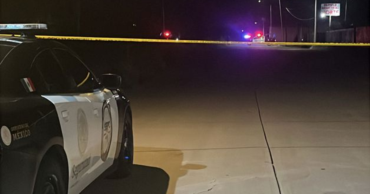 Vehículo policial en carretera nocturna con cinta de advertencia amarilla, escena del crimen en Culiacán.