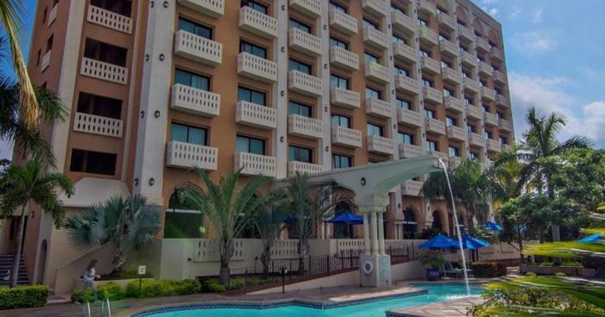 Hotel con piscina y sombrillas azules en Culiacán, Sinaloa, en un día soleado.