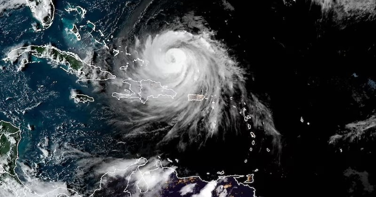 Imagen satelital del huracán Erin en el Caribe, mostrando su forma espiral y las islas de Cuba y Puerto Rico.