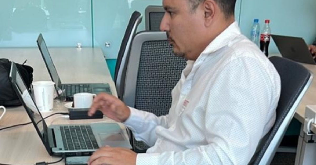 Persona trabajando en una computadora portátil en una oficina, representando la automatización del código por IA.