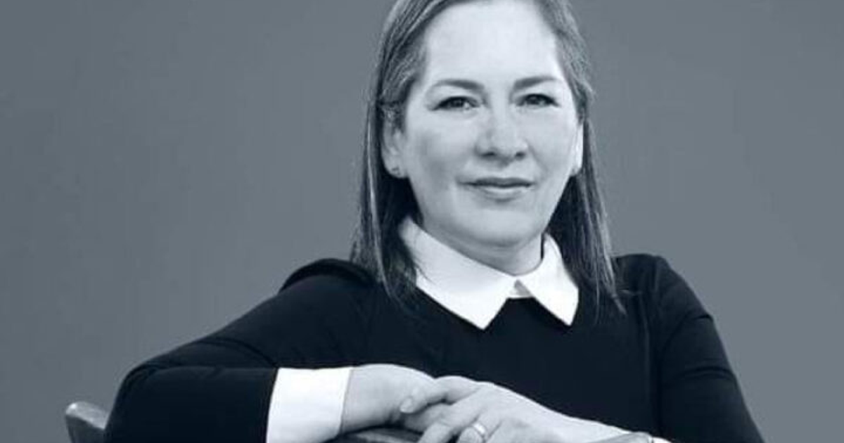 Persona sonriendo con cabello largo y lacio, blusa oscura y camisa blanca, vinculada a denuncia electoral.