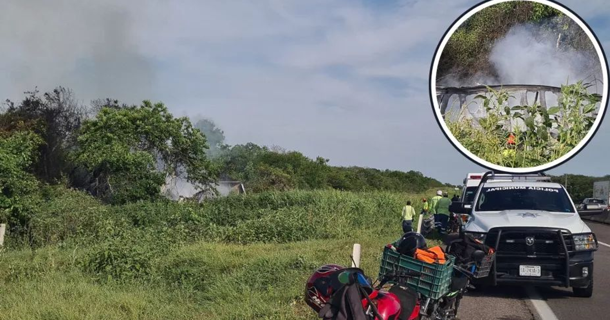 Paisaje rural con incendio en el fondo tras accidente de tractocamión en Mazatlán–Culiacán, vehículos y personas en primer plano.