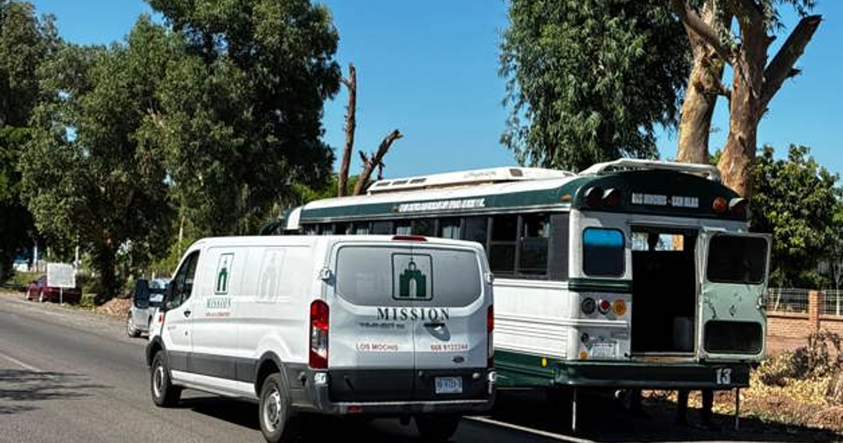 Furgón blanco y autobús verde y blanco en carretera rural, escena de emergencia cardíaca.