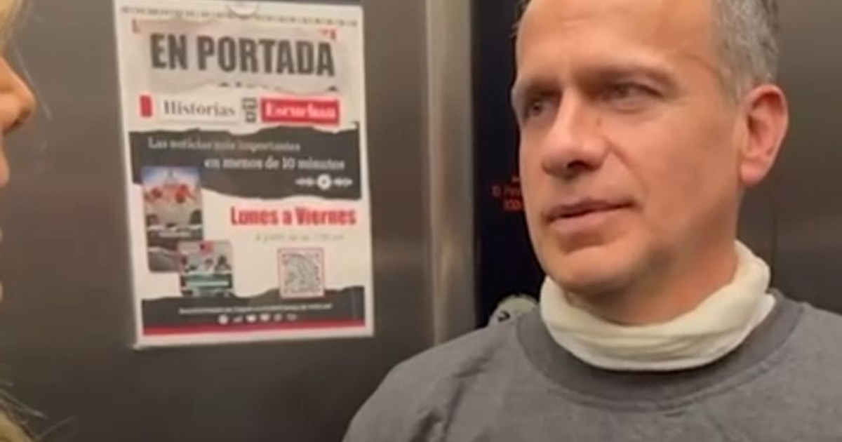 Hombre en ascensor con cartel 'EN PORTADA', vinculado a la exoneración de Israel Vallarta.