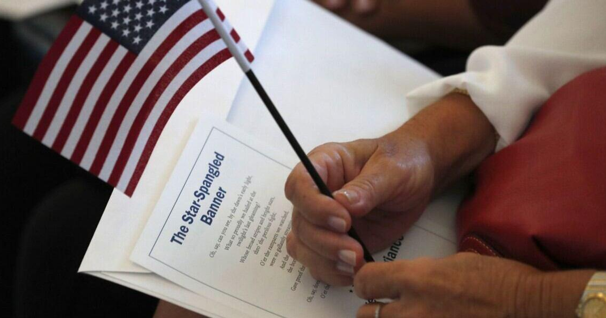 Mano con bandera de EE.UU. y letra del himno nacional