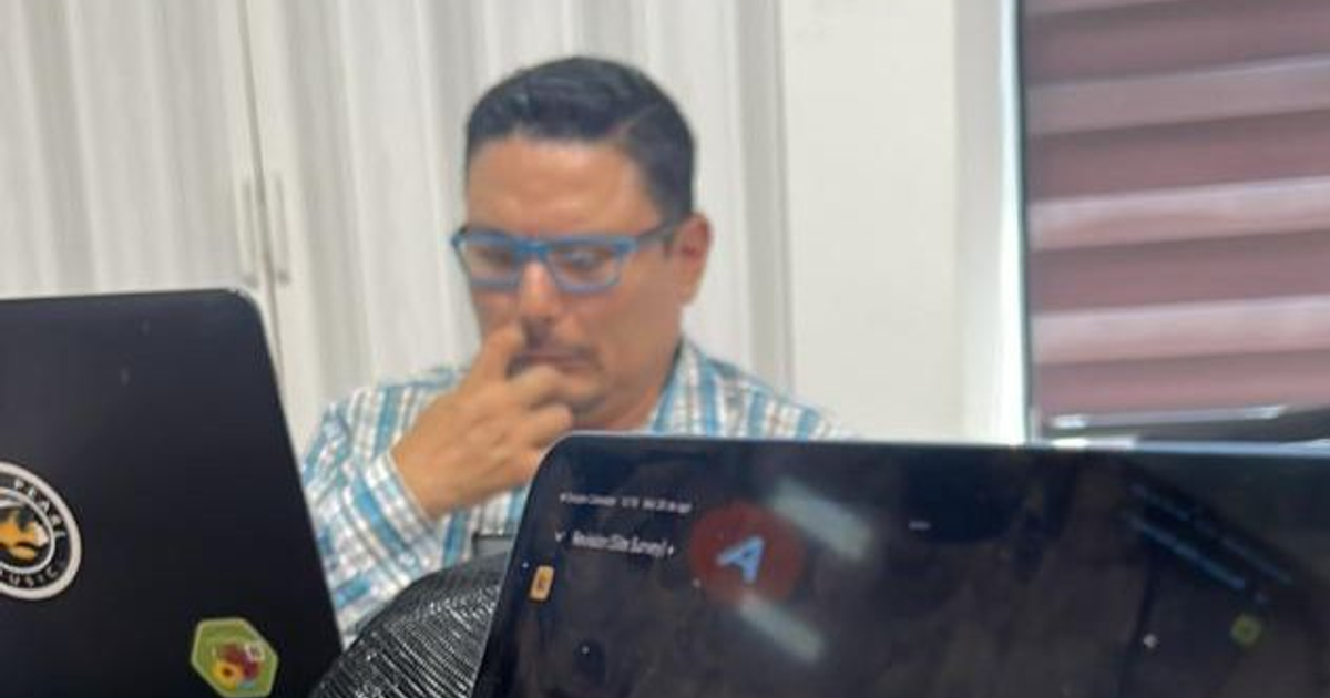 Hombre trabajando en oficina con dos computadoras portátiles