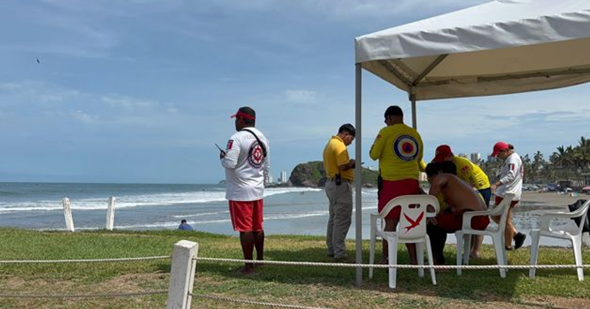 Salvavidas en la playa Camarón Sábalo, Mazatlán, con el mar de fondo y una carpa de vigilancia.