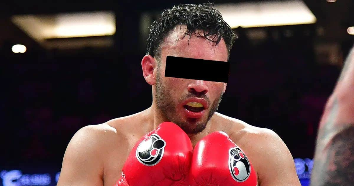 Boxeador con guantes rojos en el ring, mostrando concentración y esfuerzo.