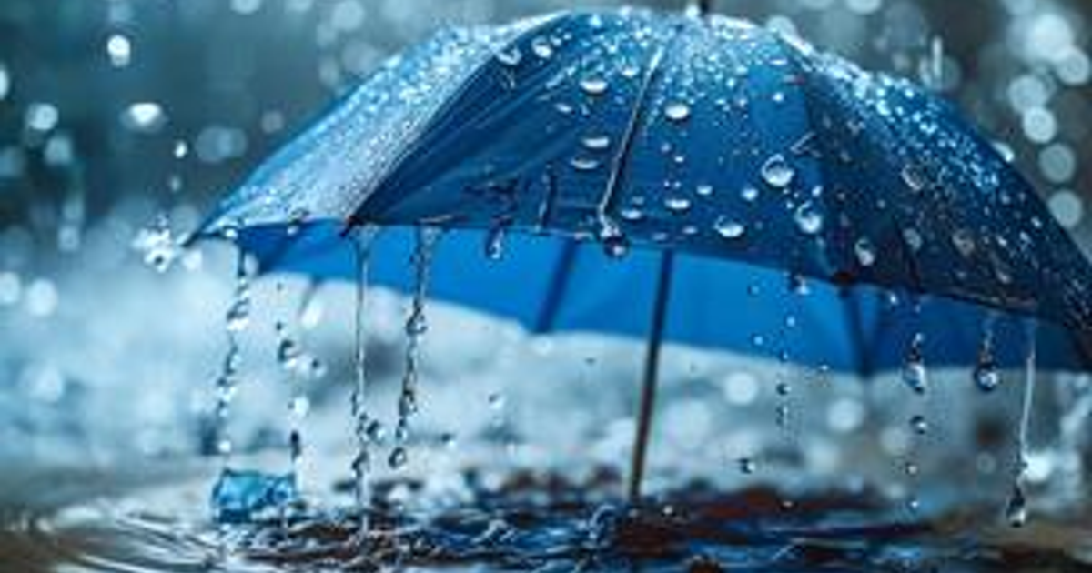 Paraguas azul bajo la lluvia en Sinaloa con gotas de agua visibles.