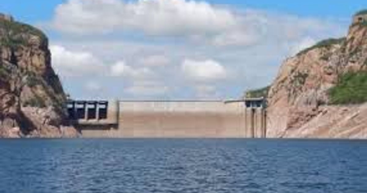 Presa de concreto entre montañas en Sinaloa con cielo despejado y nubes dispersas