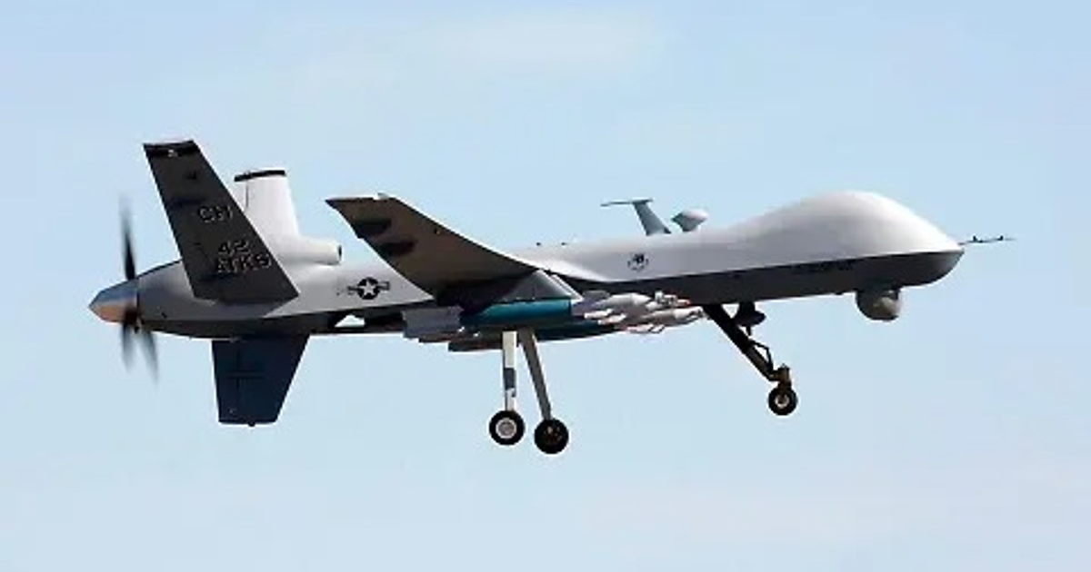 Dron MQ-9B 'Guardian' en vuelo, con hélices y armamento visible, sobre un cielo despejado.