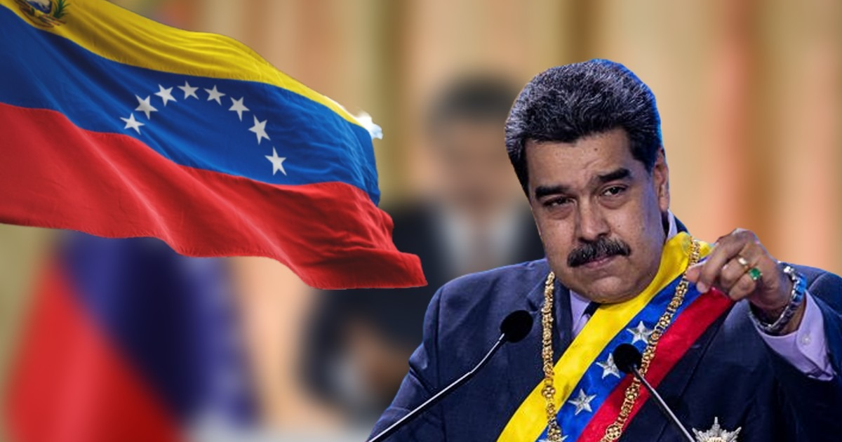 Persona hablando en evento con bandera de Venezuela detrás