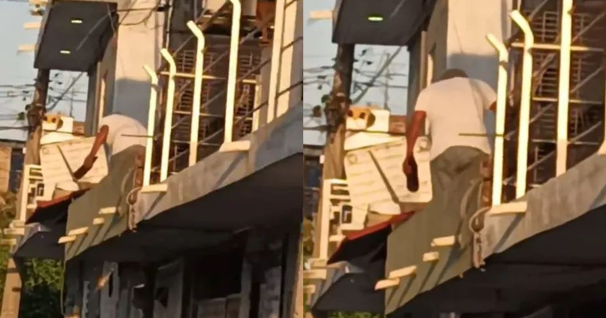 Persona en un balcón organizando cajas, con arquitectura y cables de fondo, en relación a un caso de maltrato canino en Mazatlán.