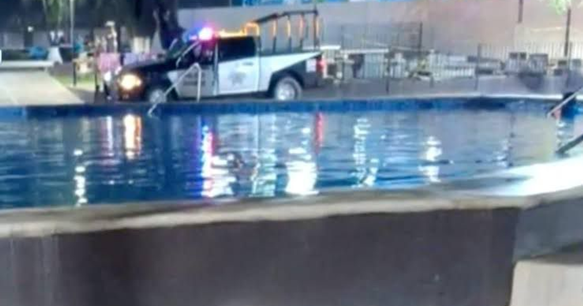 Piscina iluminada de noche con vehículo policial al lado, relacionada con incidente en Culiacán