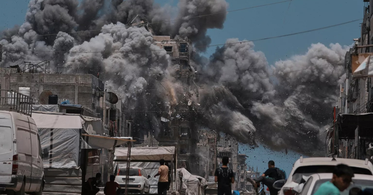 Escenario de destrucción en Gaza con humo y escombros tras explosión, en contexto de ocupación militar.