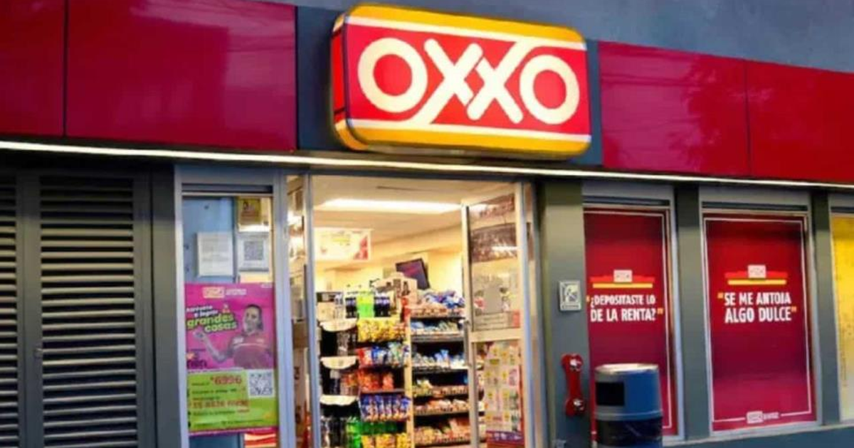 Entrada de tienda OXXO con letrero amarillo y rojo, estantes de productos y carteles promocionales.